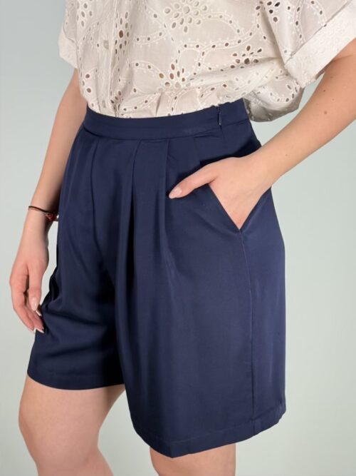Shorts fluido, di colore blu, gamba ampia modello con lam Shorts fluido con pinces sul davanti, chiusura laterale con lampo.