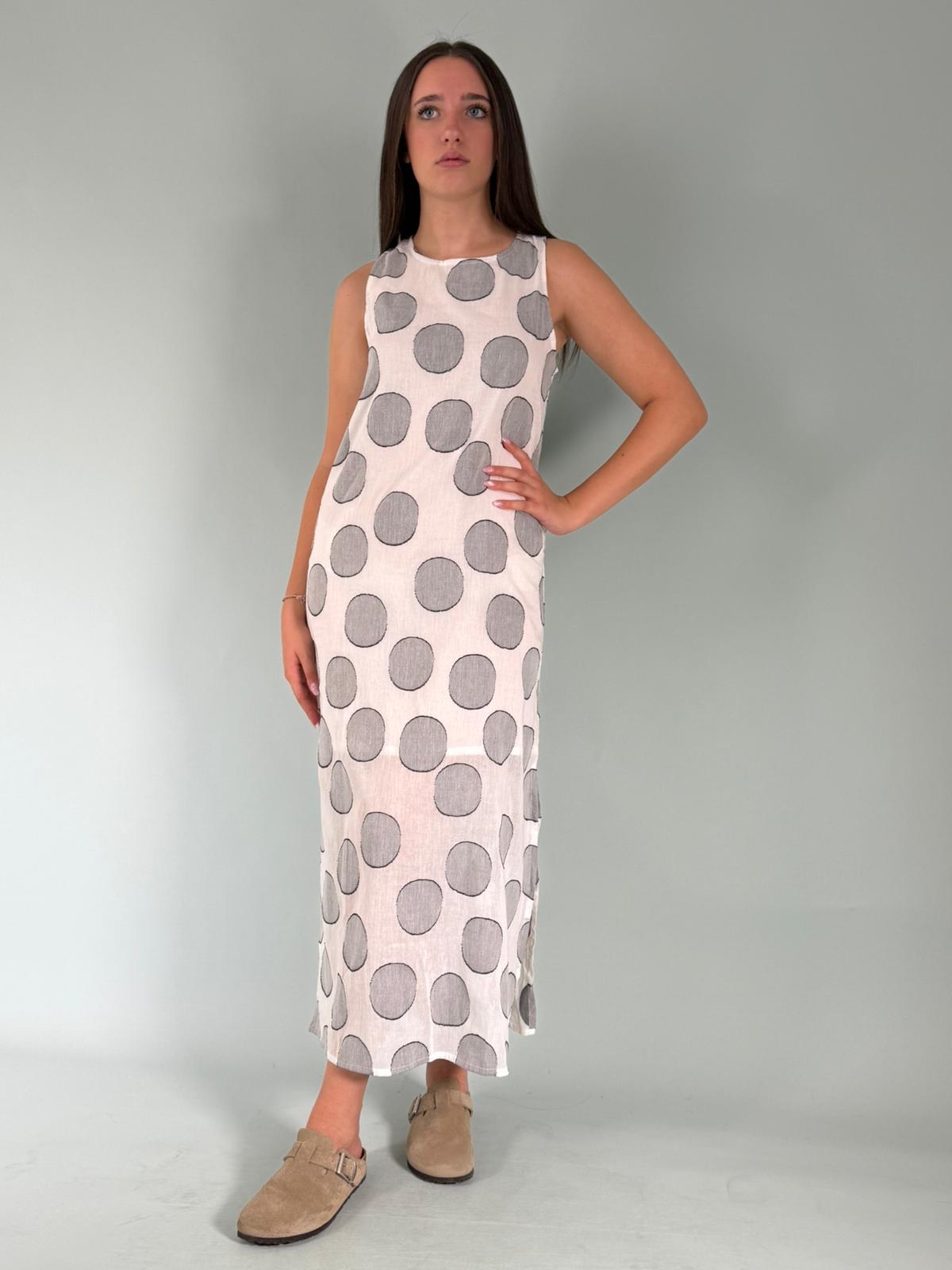 Abito a pois lungo, a girocollo con spalle larghe. Dettaglio di due spacchi laterali che donano leggerezza e stile.