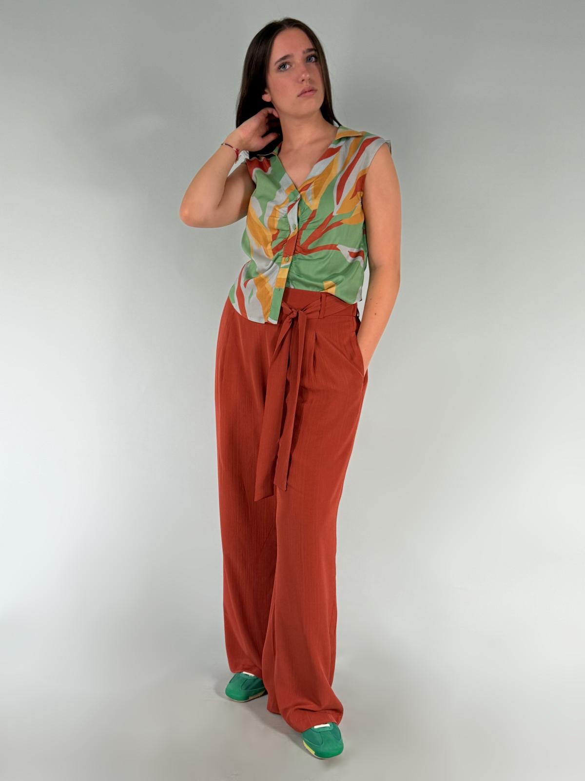 Pantalone palazzo in tinta caramel, con tasche laterali a filo, cinta ferma sul davanti e elastico sul retro.