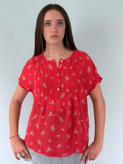 Blusa girocollo allacciata con tre bottoncini a cotrasto di colore ,manica corta scesa. modello scatolina con pieghe sul davanti da creare un movimento.