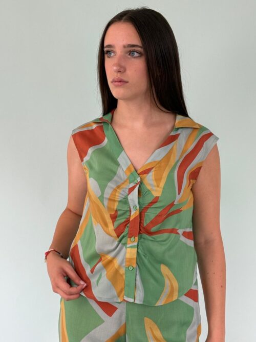 Top a fa tasia realizzato con un tessuto leggero e fluido, scollo a V, senza maniche. Allacciato sul davanti con bottoni.collo a revers