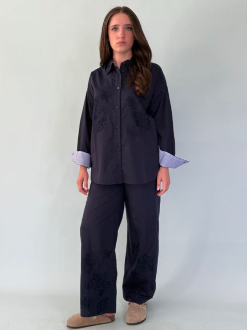 Pantalone con elastico in vita, tasche laterali, e ricamo in fondo.