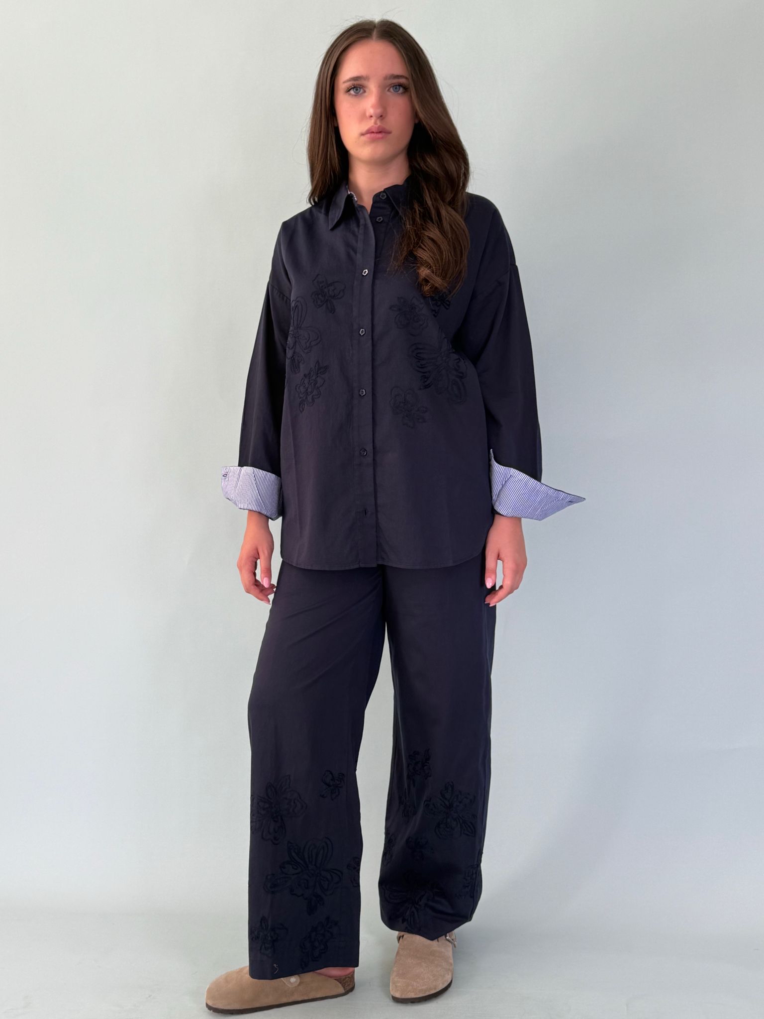Pantalone con elastico in vita, tasche laterali, e ricamo in fondo.