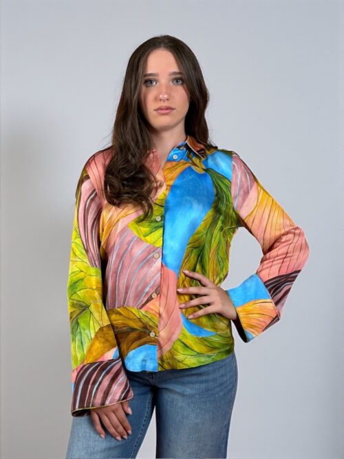 Camicia a fantasia con maniche ampie, collo a rever. Allacciata sul davanti con bottoni.