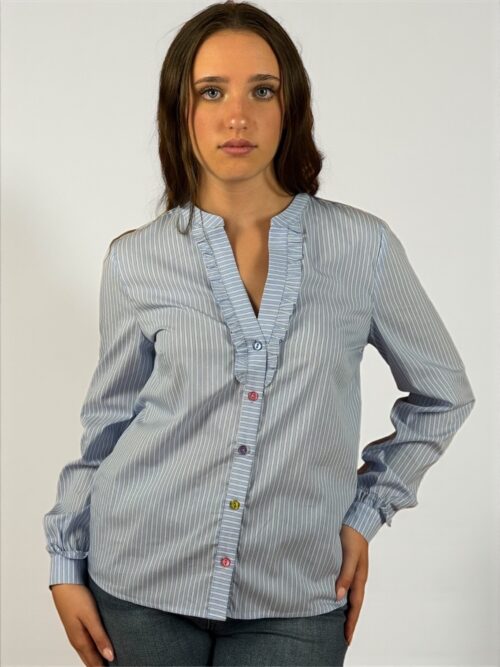 Camicia a righe celeste, allacciata sul davanti con bottoni di diversi colori. Scollatura a V manica lunga.