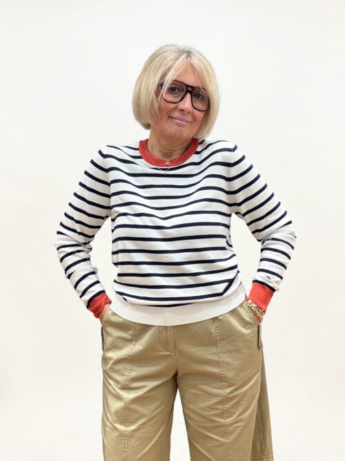 Maglia in filo a righe bianca e blu. Girocollo e polsini di colore coccio. Ideale da indossare con capi casual.