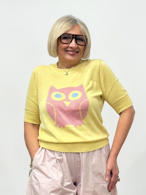 Maglia di colore giallo con un disegno a forma di gufo rosa. Girocollo e maniche corte