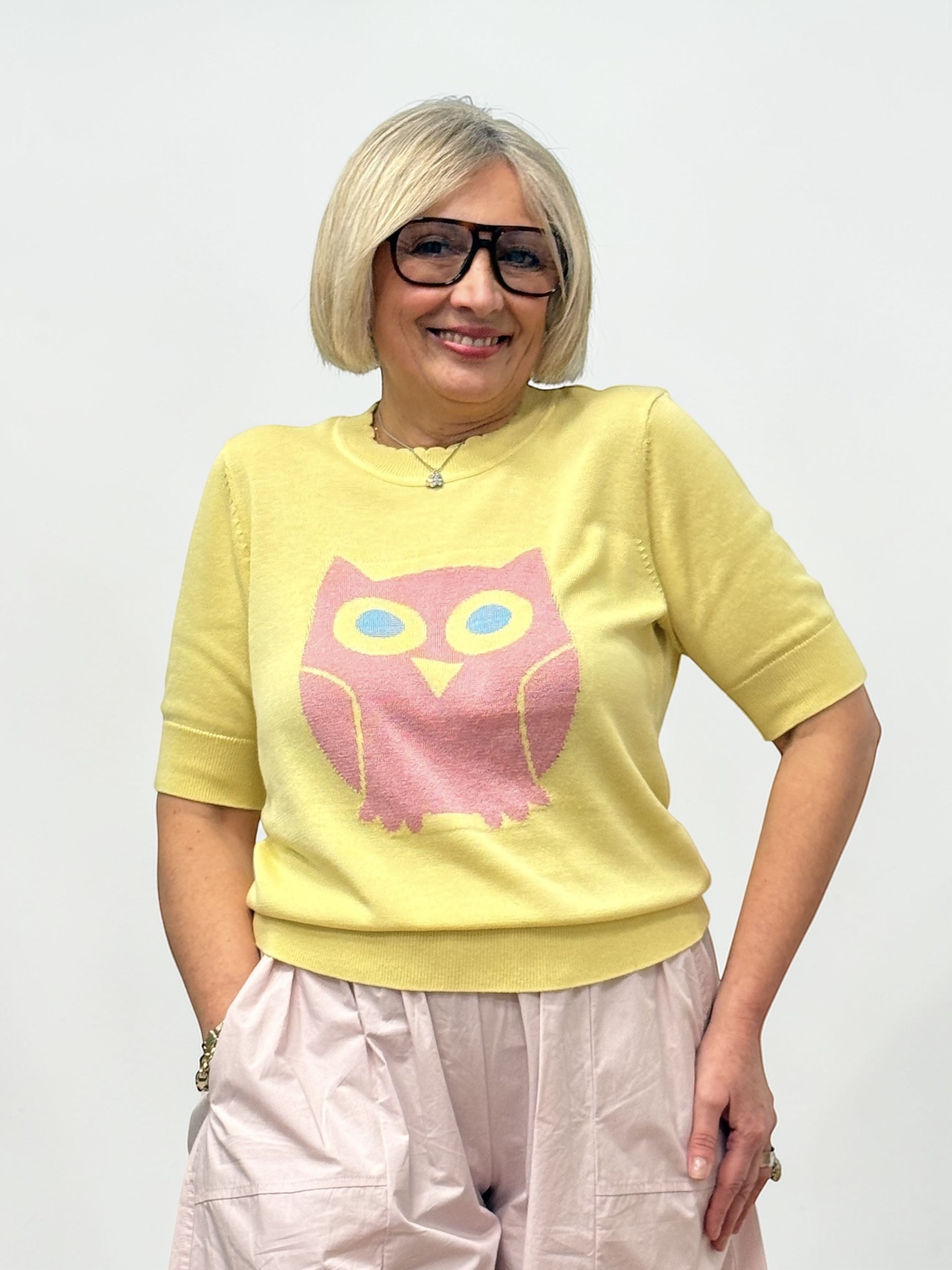 Maglia di colore giallo con un disegno a forma di gufo rosa. Girocollo e maniche corte
