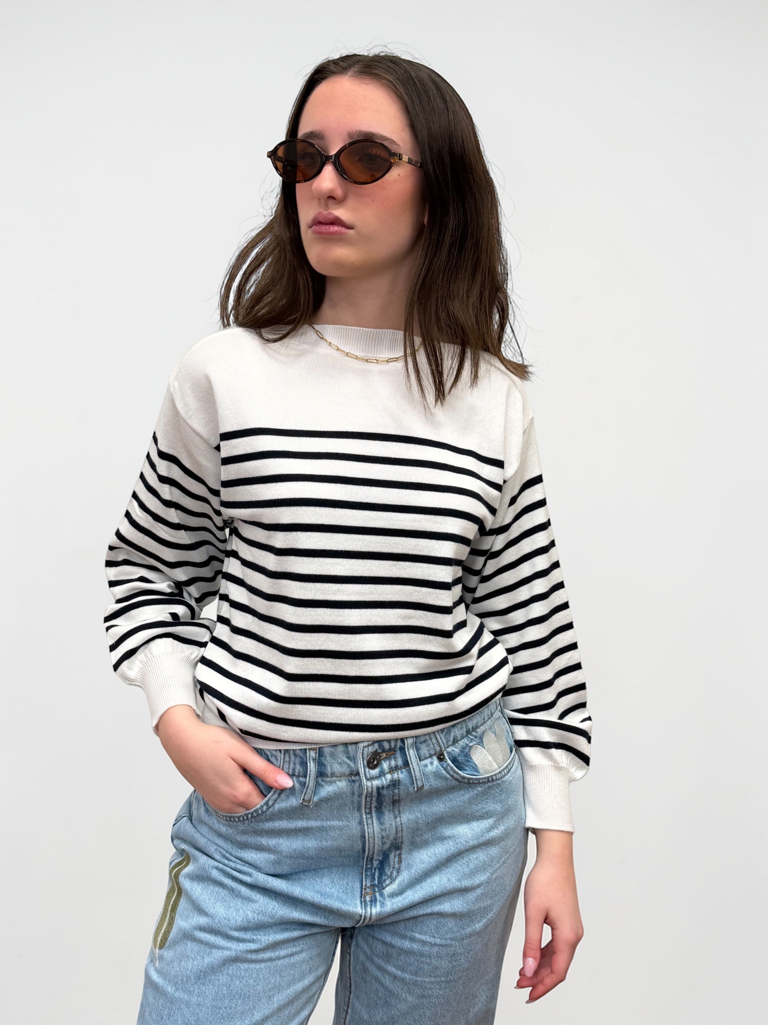 Maglia a righe bianco e blu, con collo a barca e maniche lunghe. Ideale da indossare con capi casual.